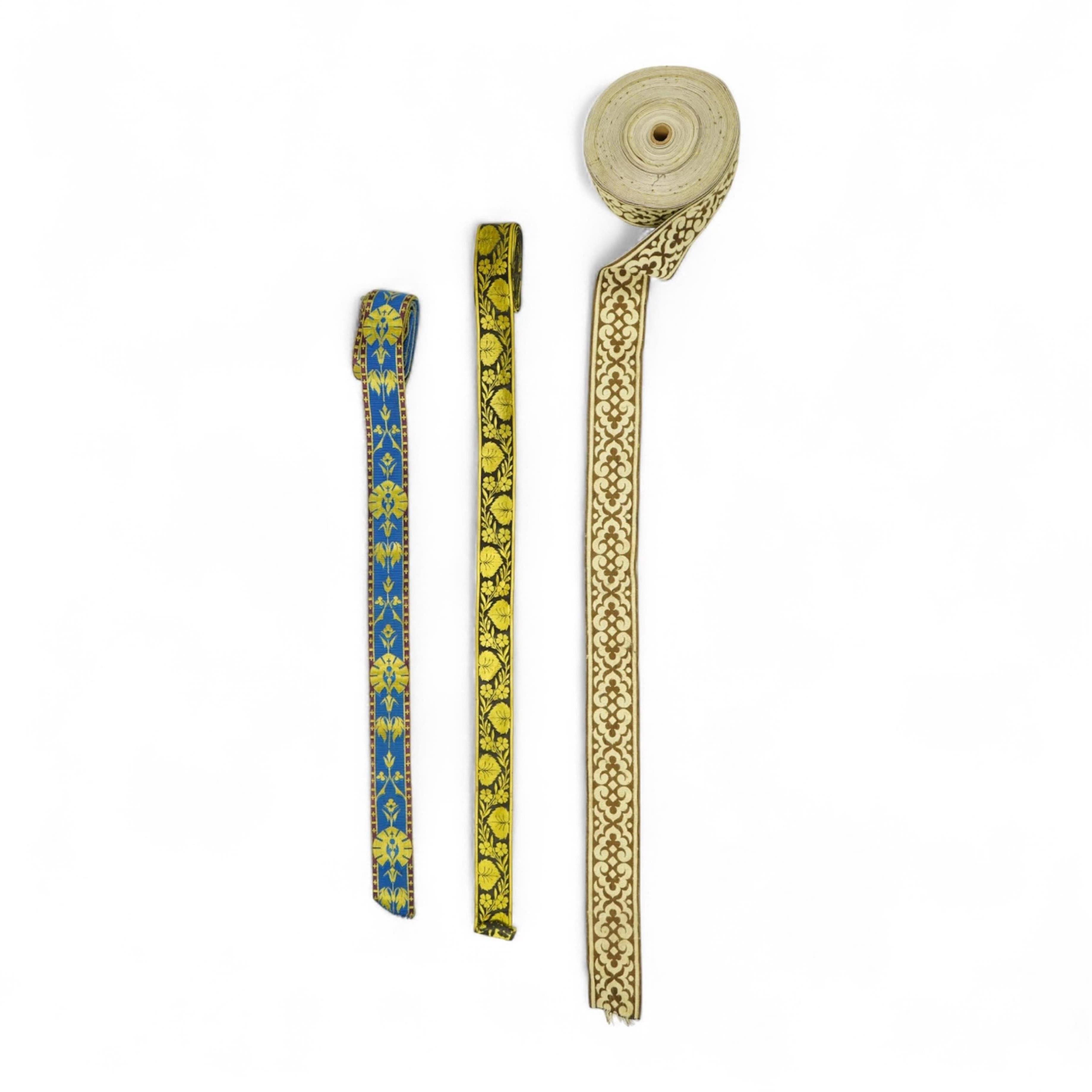 Three long lengths of late 19th century silk woven braiding. One woven in gold, turquoise and maroon silk, possibly for ecclesiastic use, in Christopher Dresser ‘style’ motifs, another in gold and black silk thread in a